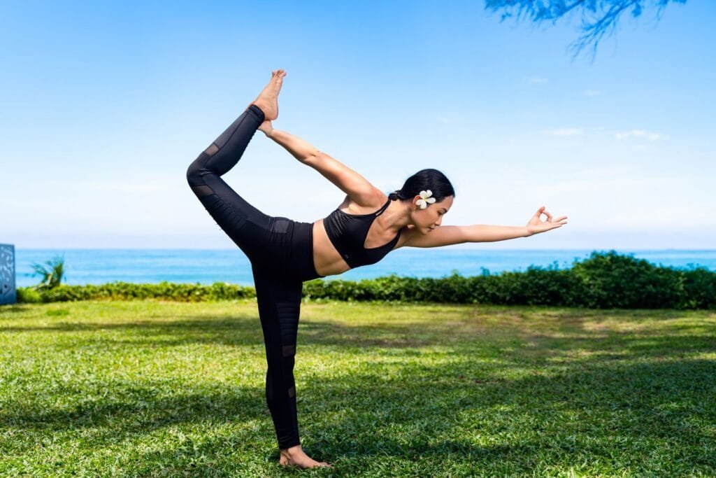 Individual yoga session on a beachfront lawn with panoramic ocean views in a quiet retreat setting.