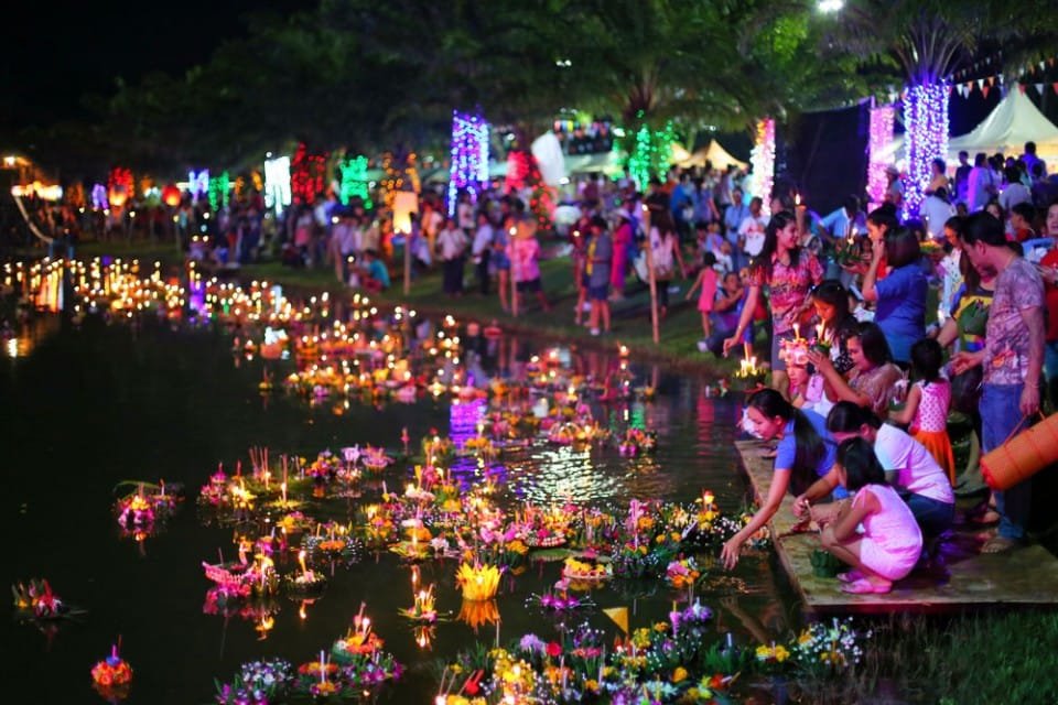Guests celebrating Thanksgiving and Loy Krathong in Thailand, releasing krathongs into the sea and lakes near Natai Beach.