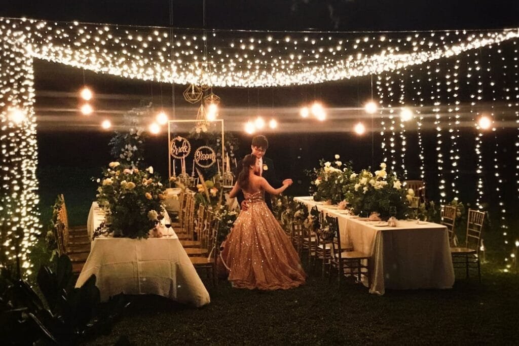 Outdoor wedding reception on the lawn at Twin Villas Natai illuminated with romantic string lights