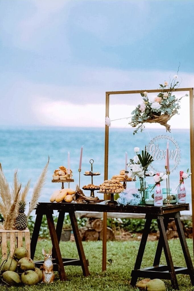 Dessert table stand on the lawn at Twin Villas Natai set for an intimate beach wedding reception