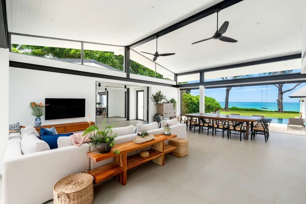 Two Villas, One Estate: A combined 10-Bedroom Private Estate near Phuket for Large Groups | Twin Villas Natai North Villa with floor-to-ceiling doors folded open to the sea — indoor-outdoor living at Twin Villas Natai, combined villas Phuket