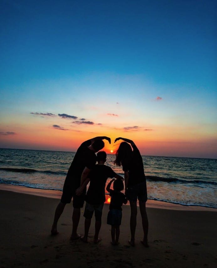 Thanksgiving vacation in Phuket — parents and children enjoying sunset by the beach at Twin Villas Natai.