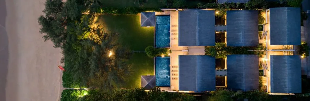 Two Villas, One Estate: A combined 10-Bedroom Private Estate near Phuket for Large Groups | Twin Villas Natai Aerial evening view of the combined Twin Villas Natai showing pools and gardens – 10 bedroom villa Phuket, group villa renta
