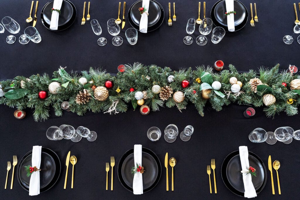Elegant Christmas dining table at Twin Villas Natai featuring a lush festive garland, gold accents, and black table décor — a luxurious holiday setup at a private Christmas villa in Phuket.