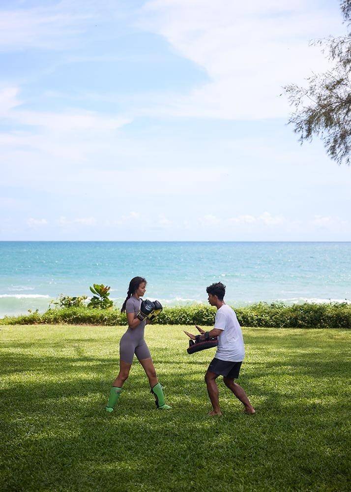 Retreat Villas Near Phuket – A Private Beachfront Wellness Sanctuary at Twin Villas Natai | Twin Villas Natai Outdoor Muay Thai practice on a beachfront lawn with ocean views during a wellness retreat.