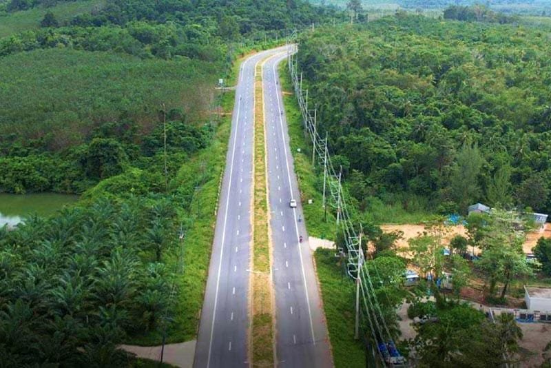 Natai Beach or Phuket? The Discerning Traveler’s Guide to Privacy and Access | Twin Villas Natai Aerial view of Highway 4 in Phang Nga province, Thailand, showing a wide divided road through green countryside with light traffic.