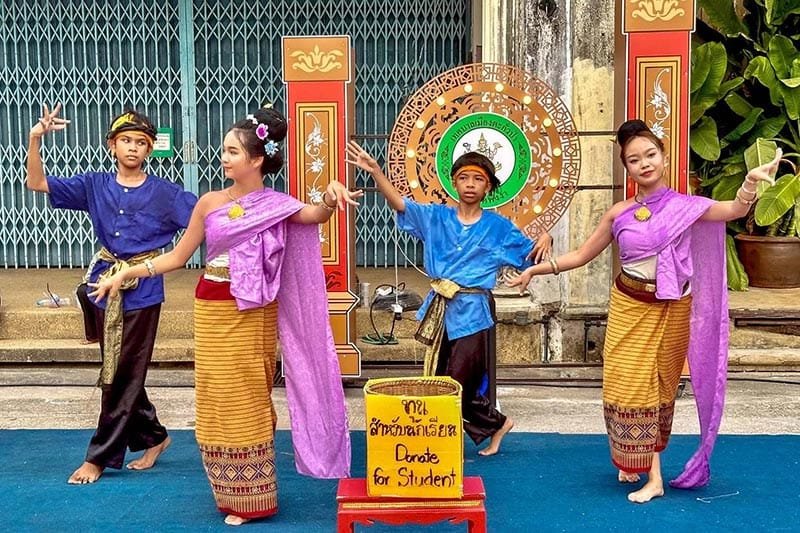 Discover Phang Nga Attractions: The Best Day Trips from Natai Beach, Thailand | Twin Villas Natai Children performing traditional Thai dance at the Sunday market in Takua Pa, Phang Nga province.
